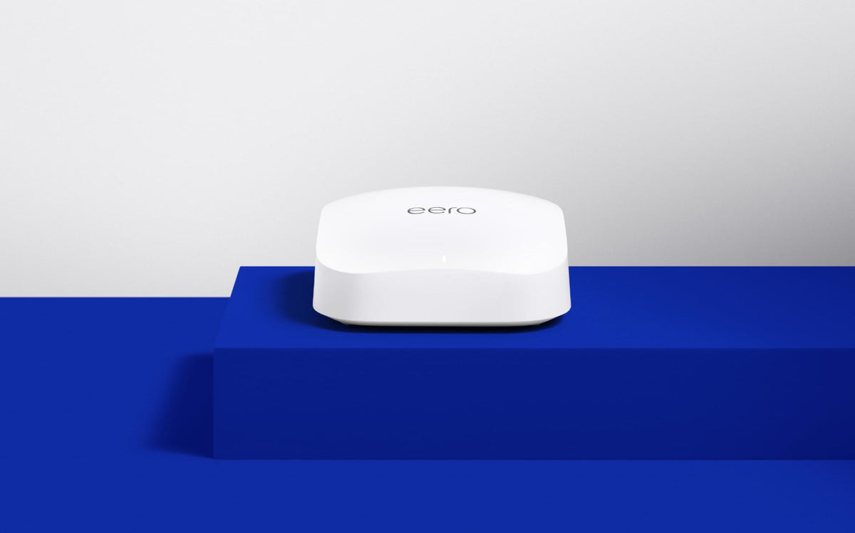 One white eero Pro 6E mesh Wi-Fi router viewed from the front on a blue display stage